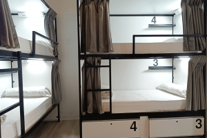 Neatly arranged bunk beds in the 12-bed dorm with private bathroom, offering a bright and comfortable stay