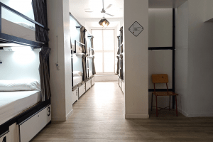 Spacious view of the 12-bed dorm entrance with private bathroom, featuring a bright and well-kept layout