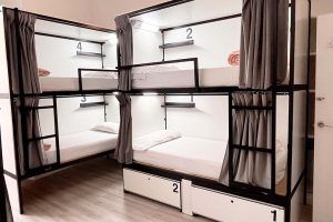 Interior view of the 6-bed shared room with private bathroom at Way Hostel Madrid, featuring spacious bunk beds and a bright atmosphere.