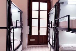Wooden bunk beds in an 8-bed room with private bathroom, ideal for young travelers