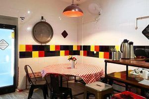 Shared kitchen at Way Hostel Madrid with table and colorful decor